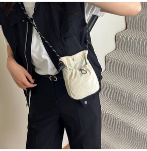 Gros plan du sac bandoulière beige en nylon avec tissu texturé et sangle en corde