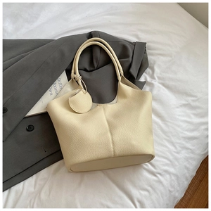 Top view of cream white tote bag with lychee texture and round pendant detail