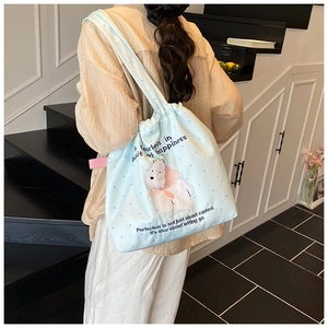 Detail of light blue drawstring tote bag with polar bear print and polka dot pattern