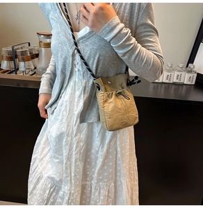 Détail d'un petit sac bandoulière en nylon kaki avec cordon et bandoulière en corde tressée