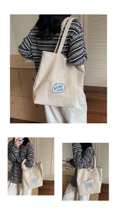 Detail of minimalist beige canvas tote bag featuring blue #today midl embroidery pocket