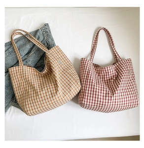 Gros plan de grands sacs cabas en toile à carreaux orange et rouge avec étiquette