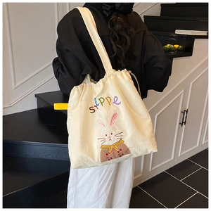 Detail of drawstring tote bag with embroidered rabbit and Stppe text on beige canvas