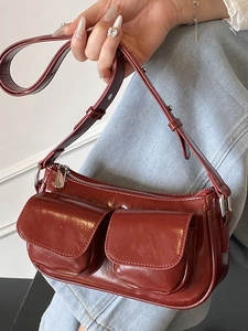 Minimalist burgundy shoulder bag with front flap pockets and glossy patent finish