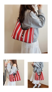 Detail of red and white striped tote bag with silver ring buckle and black leather strap