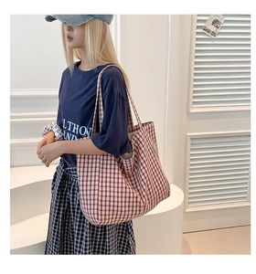Détail du grand sac cabas en toile à carreaux rouges avec l'étiquette de marque latérale