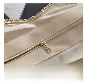 Close-up of the elegant gold zipper detail and fine fabric lining on the woven tote bag