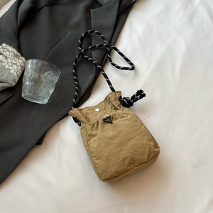 Vue détaillée du petit sac bandoulière en nylon kaki avec boucle métallique et cordon bicolore
