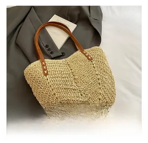 Close-up of beige woven texture tote bag with brown leather handles and X-shape stitching