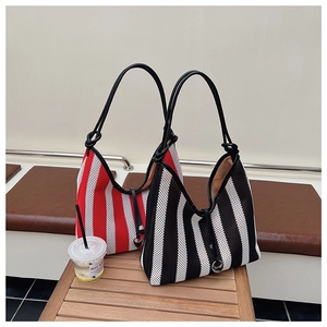 Detail of striped mesh tote bags with leather handles and knot accents on wooden bench