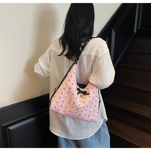 Detail of pink bubble fabric tote bag with bow prints and heart metal charm decoration