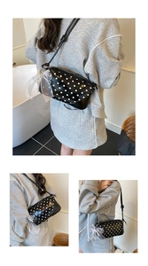 Close-up of black polka dot bag with white organza bow and pearl charm detail