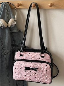 Pink bubble puff textured shoulder bag with black bows and sleek leather straps