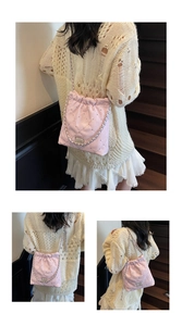 Detailed macro view of pink quilted bucket bag with silver studs and chain strap details