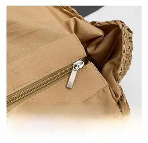 Detail of matte metal zipper and fabric lining on woven straw beach tote bag