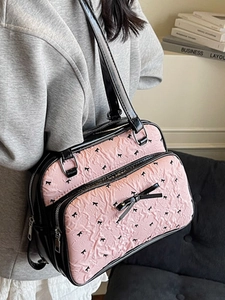 Pink bubble texture shoulder bag with black bow print and metallic silver zipper detail