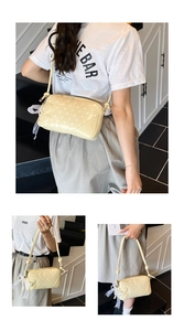 Detail of yellow baguette bag with white polka dots and lace bow charm accessory