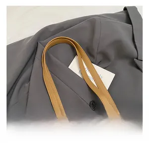 Detail of straw woven tote with tan leather handles and hollow circle pattern
