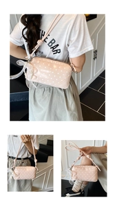 Detail of pink polka dot bag featuring lace bow, pearl pendant and adjustable strap