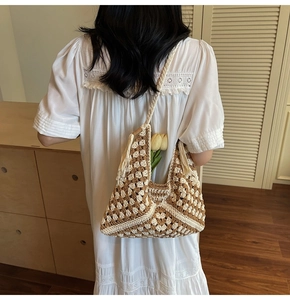 Detail of hand-crocheted shoulder bag featuring geometric patterns and a tassel charm