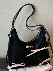 Fashionable black patent leather tote bag with pink satin bows and silver heart rivets