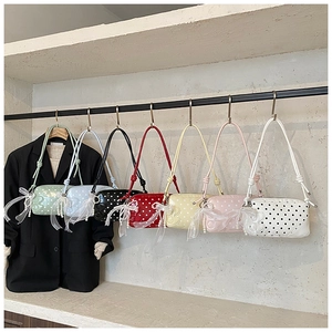 Close-up of stylish polka dot baguette bags in seven vibrant colors on a display rack