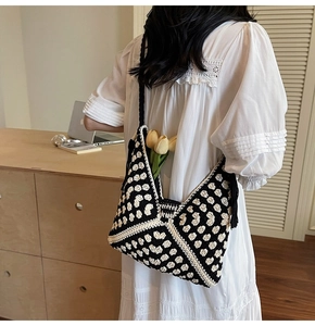 Detail of hand-woven black and white heart pattern tote bag with tulip decoration