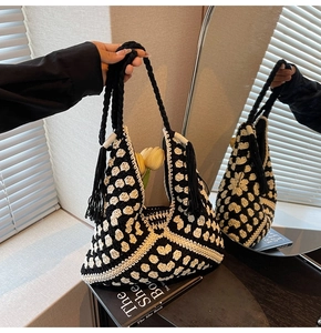 Close-up of black and white crochet tote bag with woven flower pattern and long tassels