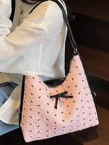 Pink tote bag with black bow prints and silver heart charm pendant for women