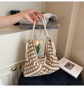 Detail view of woven tote bag with geometric pattern and bohemian tassel handle