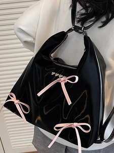 Glossy black patent leather tote bag with pink satin bows and silver heart rivets