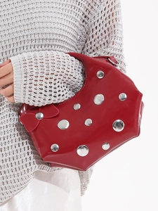 Fashionable dark red patent leather crescent bag with silver rivets and bow detail