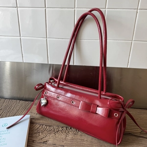 Detail view of burgundy retro shoulder bag with silver heart pendant and ribbon bows