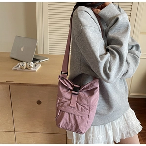 Détail du sac bandoulière en nylon violet avec boucle noire et sangle réglable