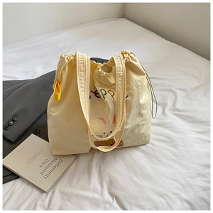 Detail of canvas tote bag with colorful HAPPY embroidery and cute rabbit pattern