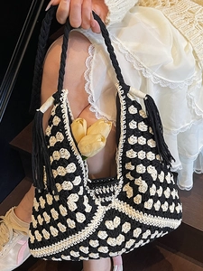 Handmade woven tote bag with monochrome floral pattern and decorative side tassels