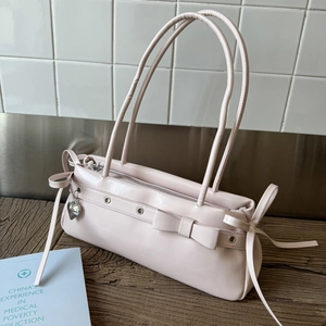 Detailed view of pale pink Y2K style handbag with bow and heart charm accents