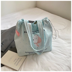 Detail of light blue canvas tote bag with polar bear embroidery and drawstring closure