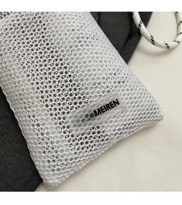 Close-up of white mesh honeycomb texture and transparent PVC logo tag on mobile phone bag