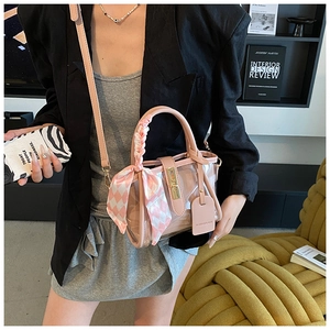 Detail of pink transparent bucket bag with silk scarf handle and metal clasp