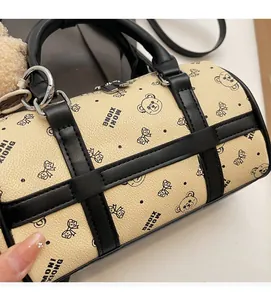Detail of PU leather barrel bag with teddy bear pattern and plush bear charm