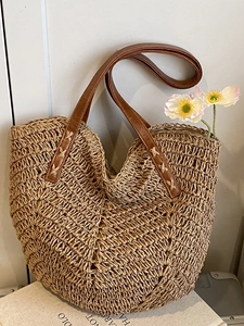 Handwoven straw tote bag with V-shaped texture and brown leather handles for beach holiday