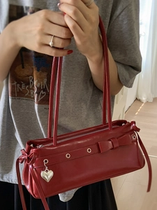 Fashionable red glossy underarm bag with bow decoration and heart pendant accessory
