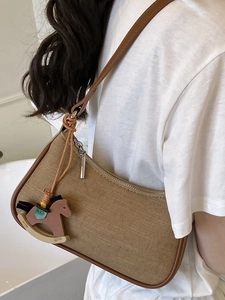 Chic canvas hobo bag for women in khaki with a wooden horse charm on a shoulder strap