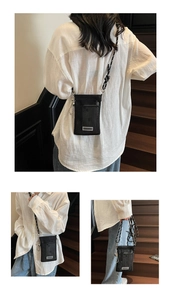 Detail view of black mesh phone crossbody bag featuring woven rope strap and metal accents