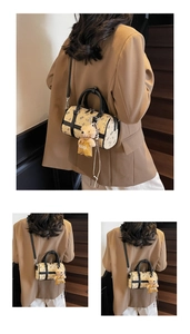 Detail of a chic apricot Boston bag with bear patterns and a plush bear pendant accessory