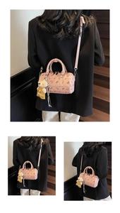 Detailed macro view of pink Boston bag with cartoon bear prints and plush charm accessory