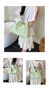 Detailed view of light green gingham backpack with luckygirl print and bear charm