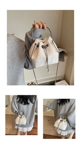 Detail of white bucket bag featuring silver butterfly charm and elegant pearl tassels