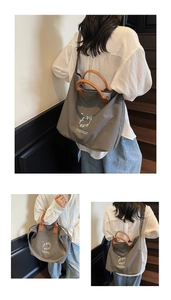 Detail of grey canvas tote bag with brown leather handles on indoor wooden stairs